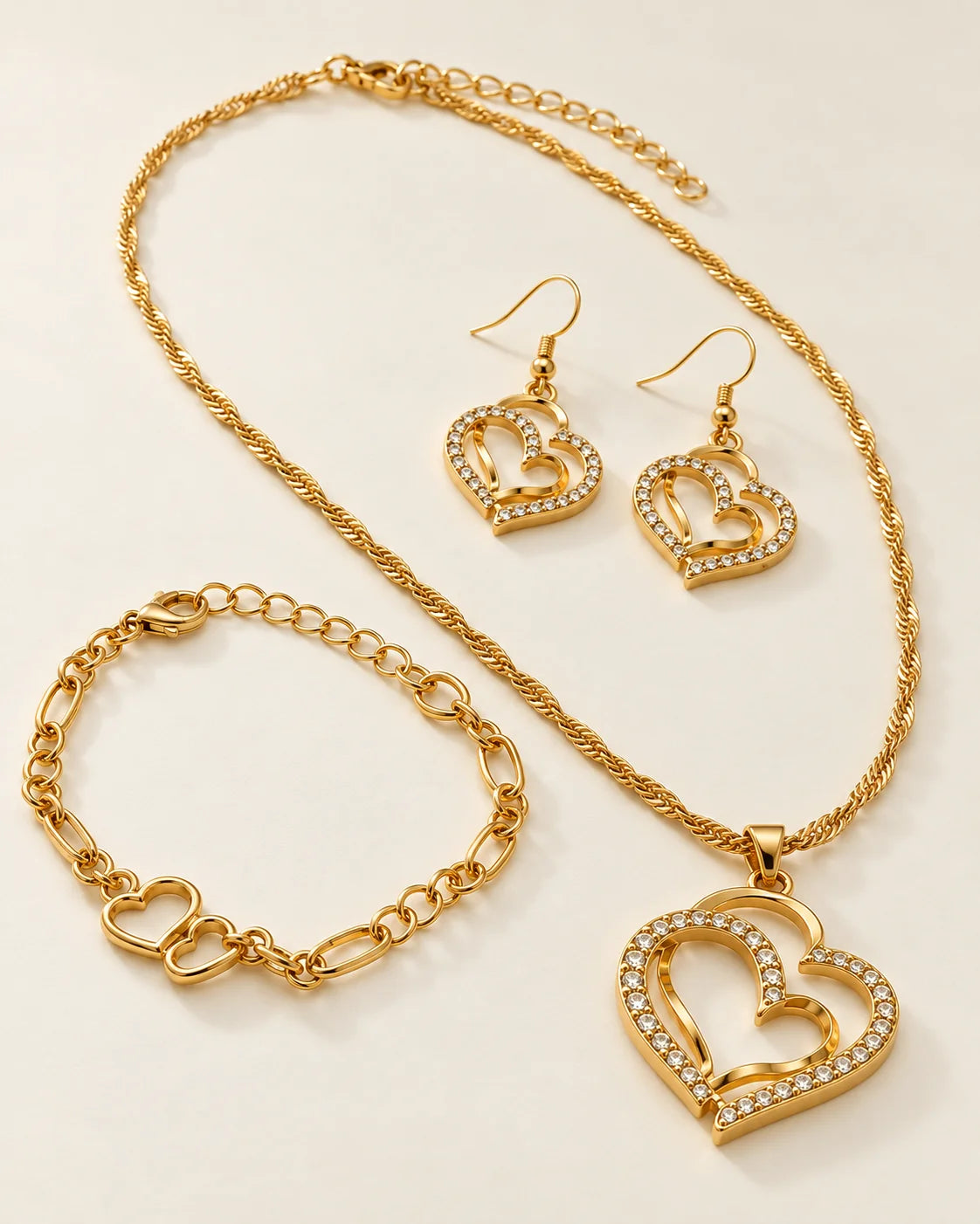 Gold-tone double heart jewellery set with pendant necklace, hook earrings and heart chain bracelet