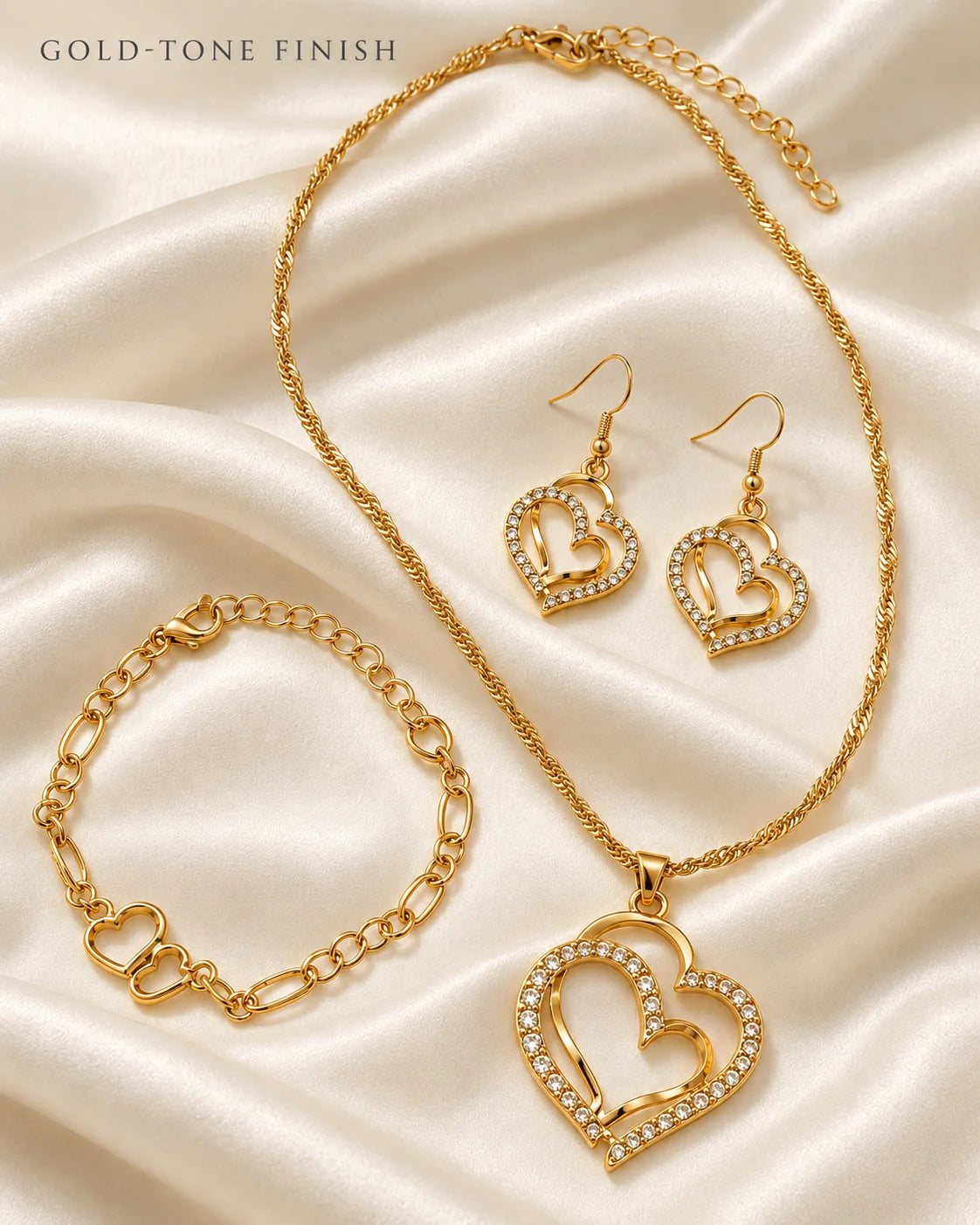 Gold double heart necklace, earrings and bracelet set on ivory satin