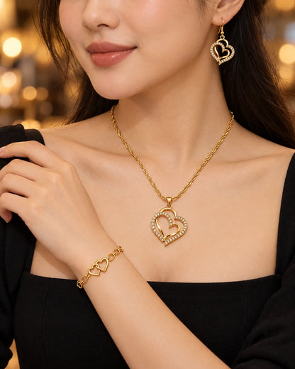 Woman in a black top wearing the gold double heart necklace, earrings and bracelet