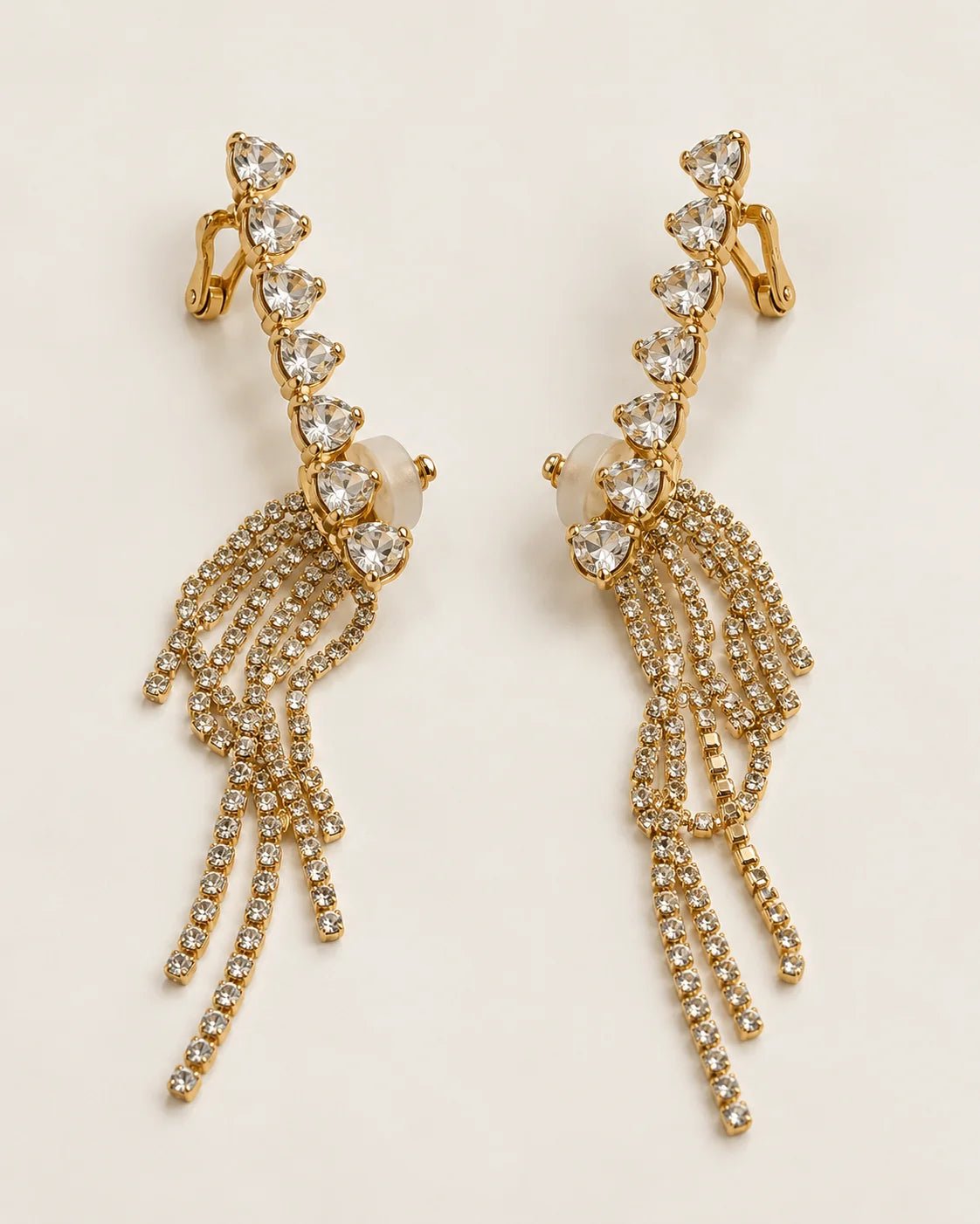 Cascade gold heart crystal tassel ear climber earrings, pair shown on cream