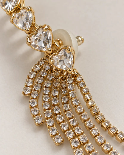 Macro detail of claw-set heart crystals and gold rhinestone tassels