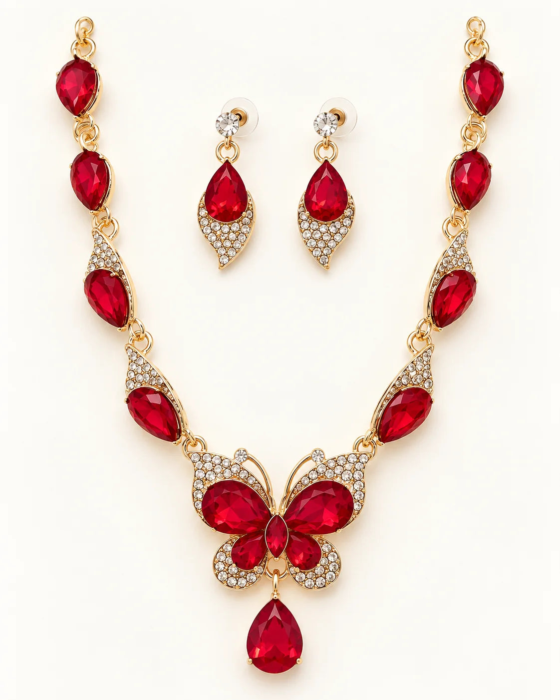 Papillon red crystal butterfly necklace and earring set in gold tone laid flat on cream