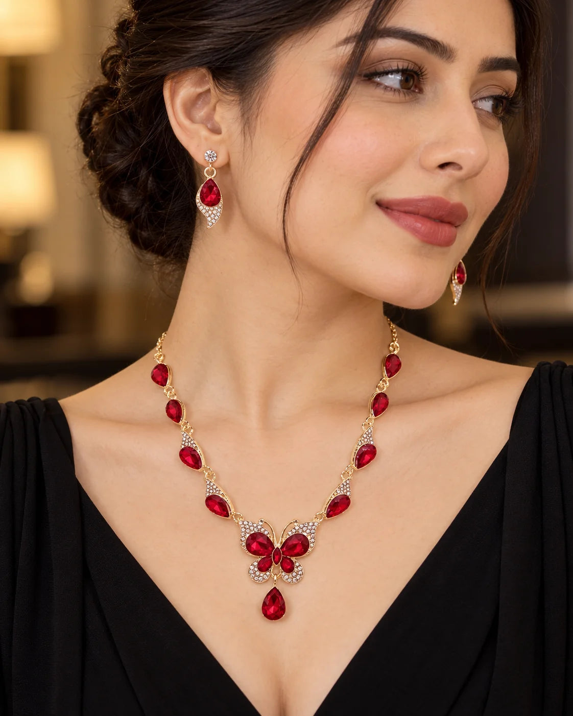 Woman in a black V-neck dress wearing the red butterfly jewellery set