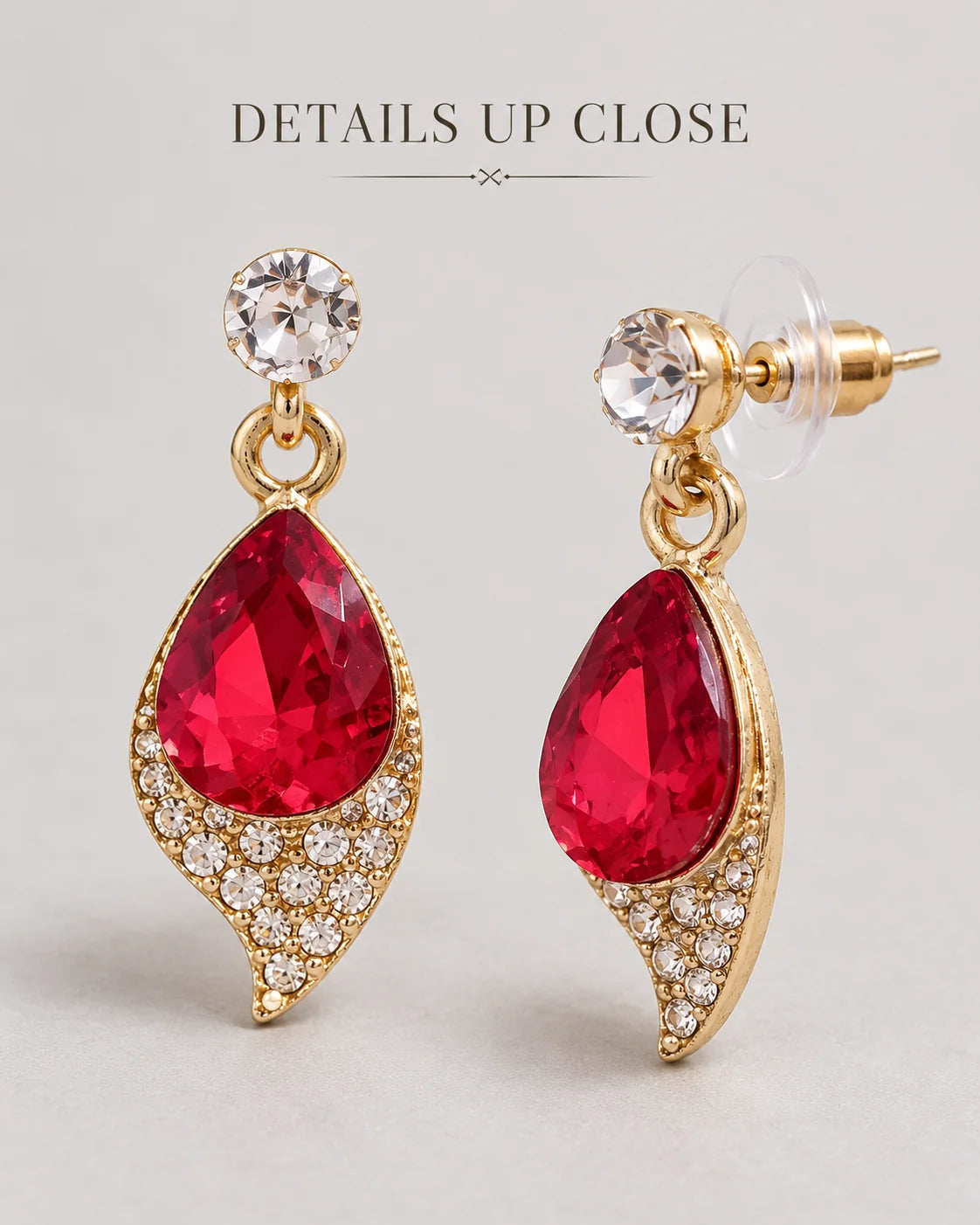 Close-up of the red teardrop drop earrings with rhinestone leaf frame and crystal stud tops