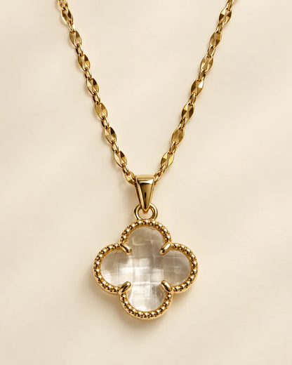 Fortuna clear clover pendant with a beaded gold-tone border on a cream background