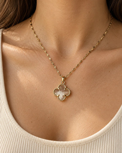 Model wearing the Fortuna clear clover pendant necklace with an ivory scoop-neck top