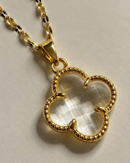 Close-up of the Fortuna clear clover pendant showing the faceted translucent centre and claw setting