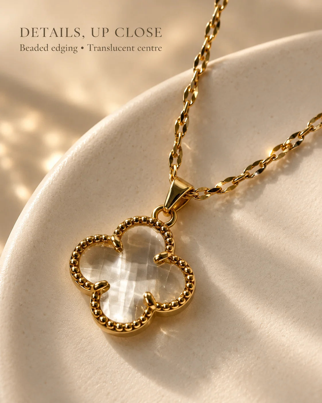 Details up close: Fortuna clear clover pendant with beaded edging in warm light