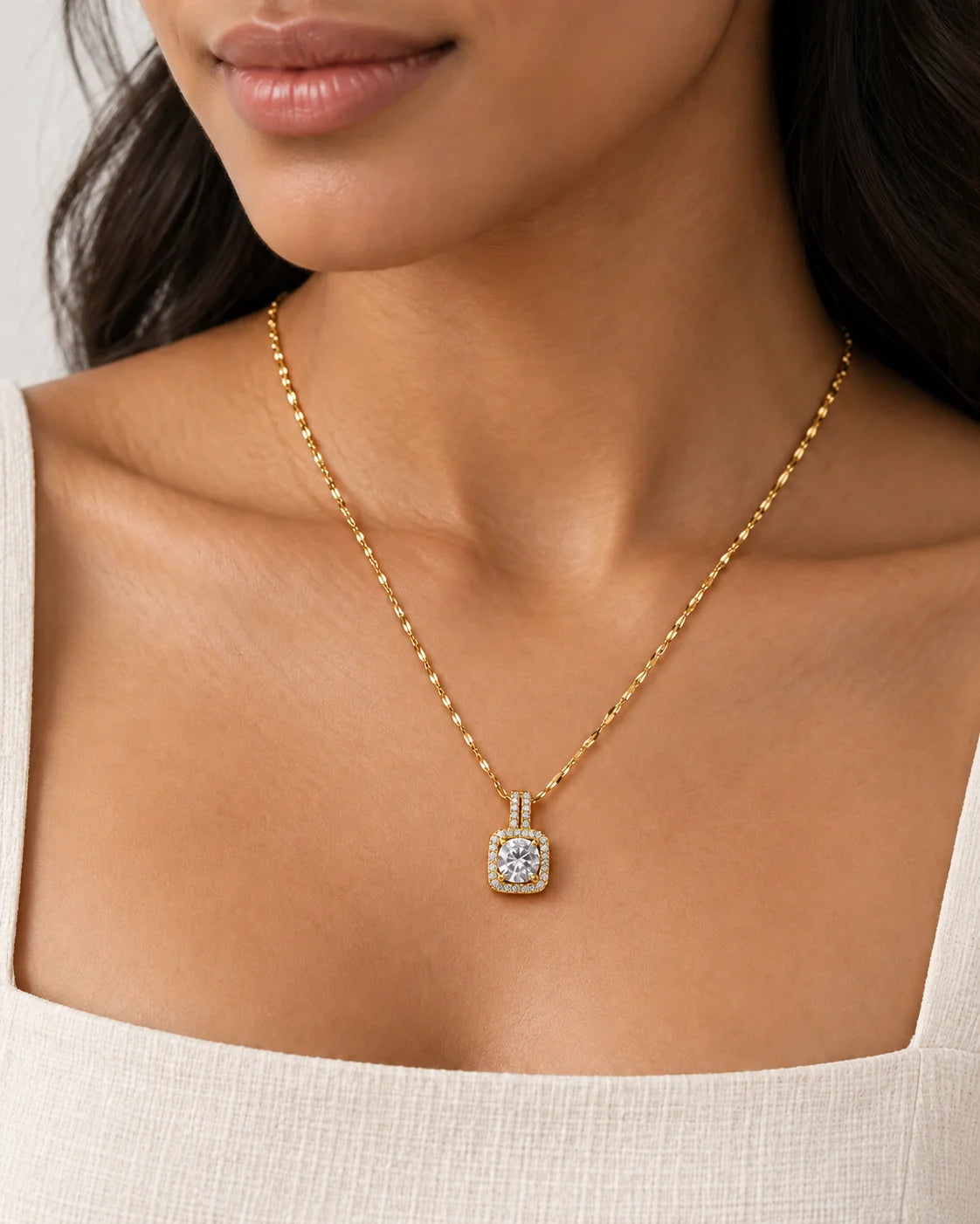 Close-up of a model wearing the Celeste gold cushion halo pendant necklace