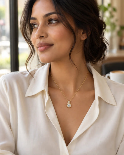 Model in a white shirt wearing the Celeste gold halo pendant in a café