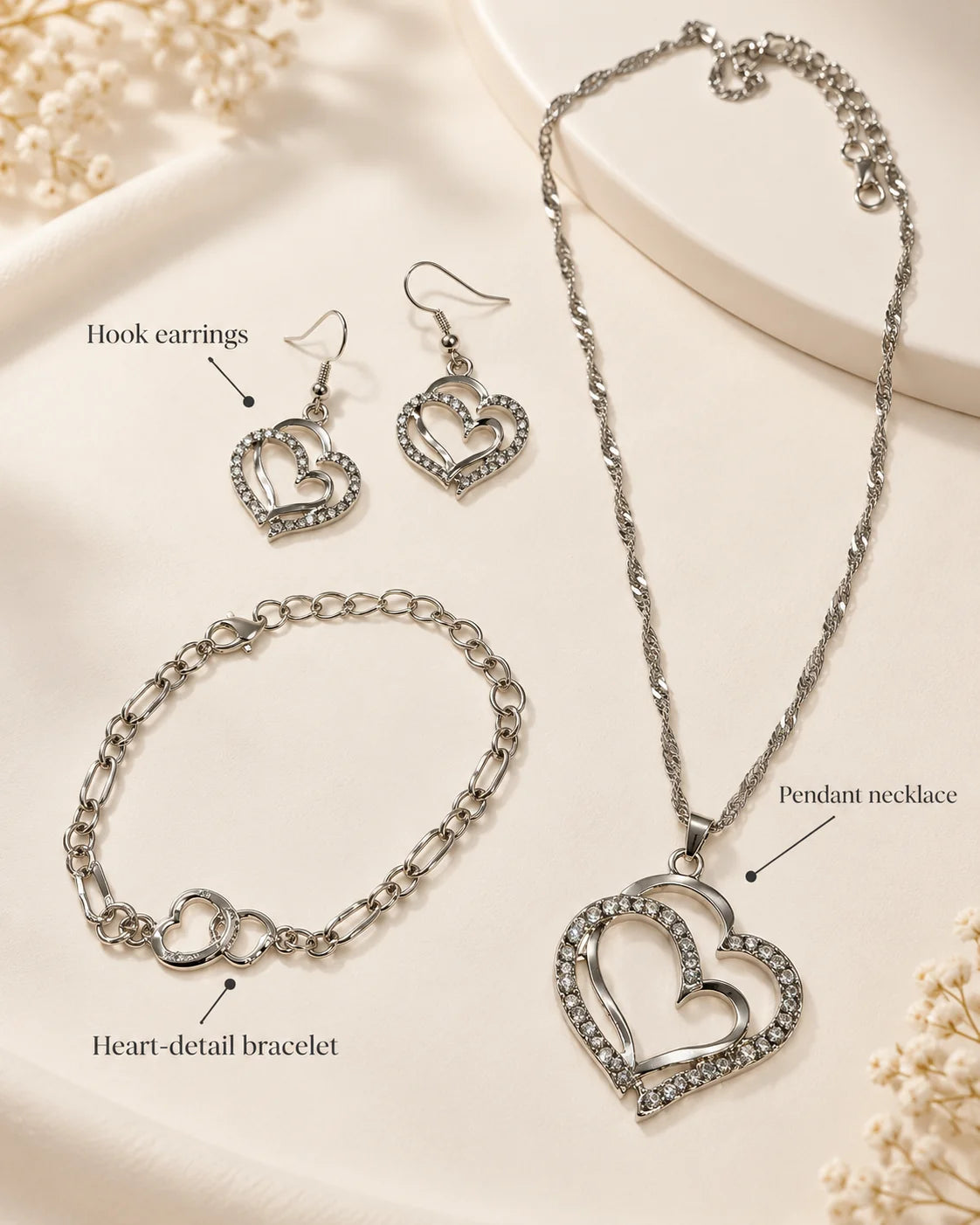 Silver heart jewellery set showing hook earrings, pendant necklace and heart-detail bracelet