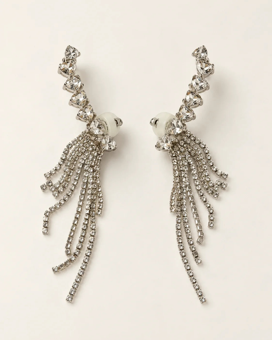 Cascade silver heart crystal tassel ear climber earrings, pair shown on cream