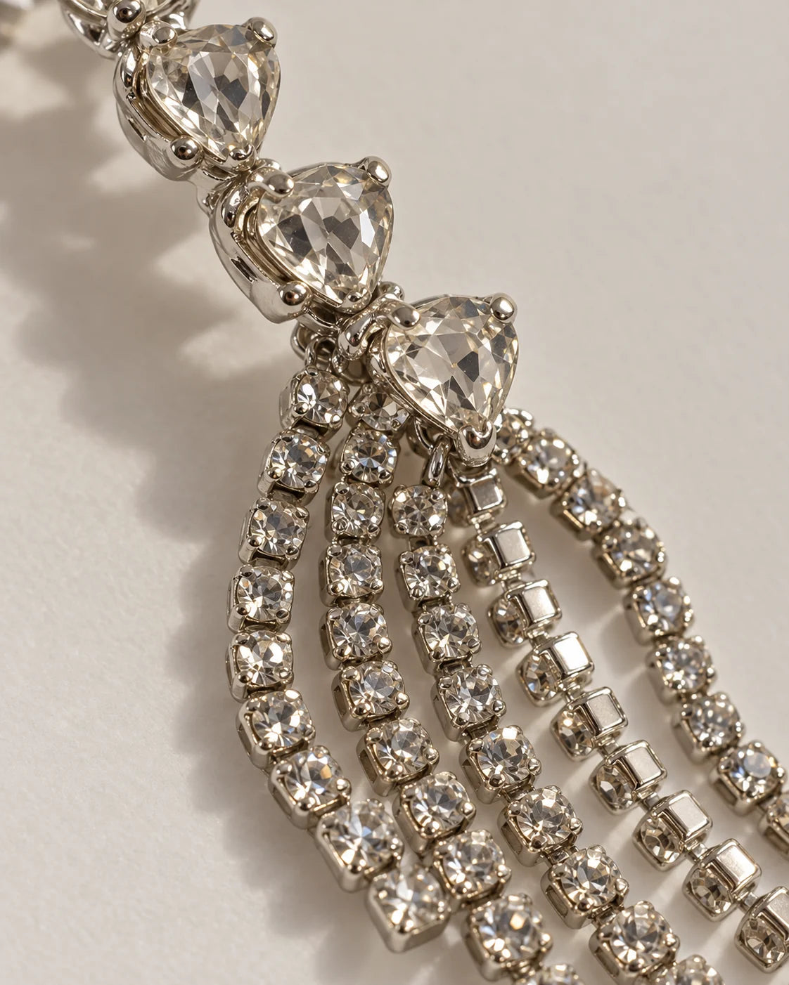 Macro detail of claw-set heart crystals and silver rhinestone tassels