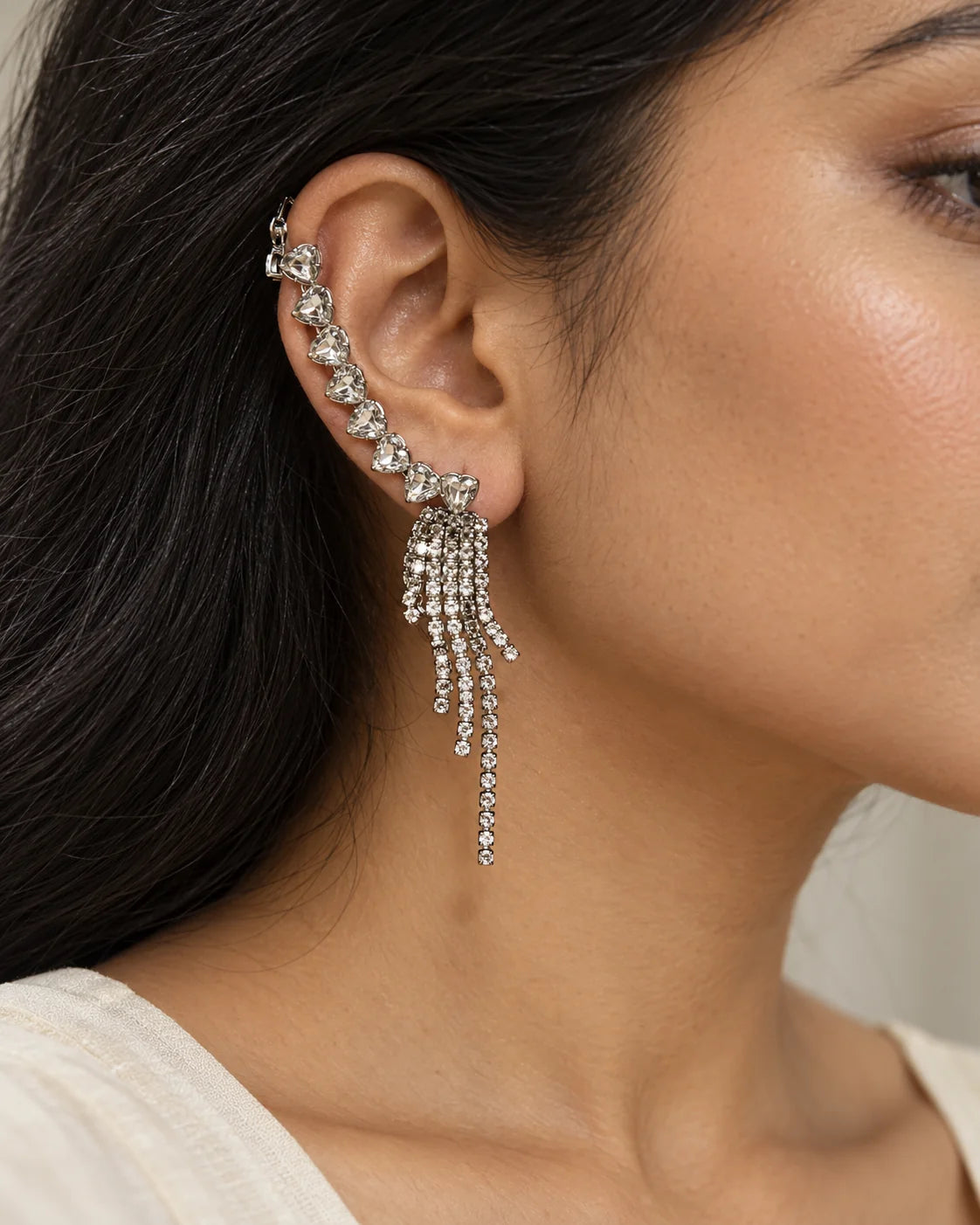 Portrait of a woman wearing the silver heart crystal tassel ear climber