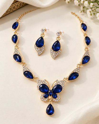 Navy blue butterfly necklace and teardrop earrings in gold tone styled with white flowers