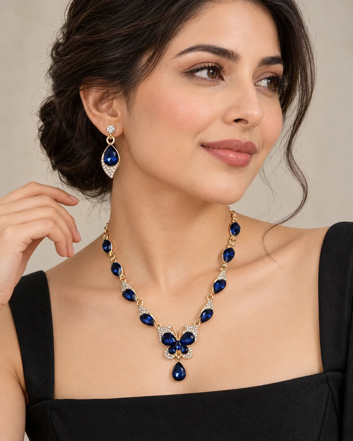 Woman in a black top wearing the navy blue crystal butterfly necklace and earrings