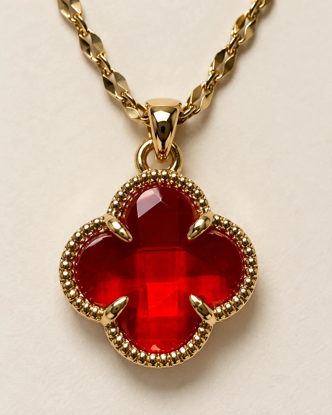 Close-up of the Fortuna cherry red clover pendant showing the faceted stone and claw setting