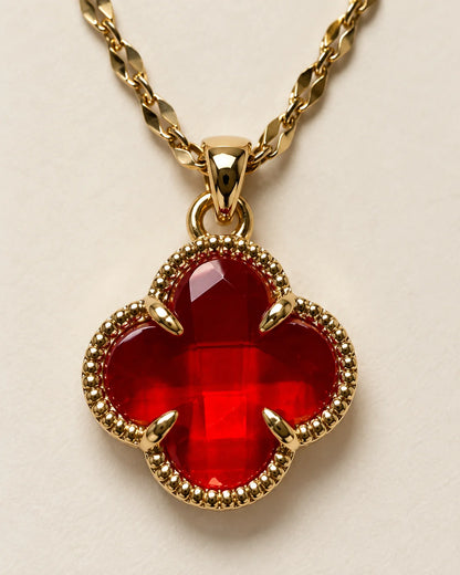 Close-up of the Fortuna cherry red clover pendant showing the faceted stone and claw setting