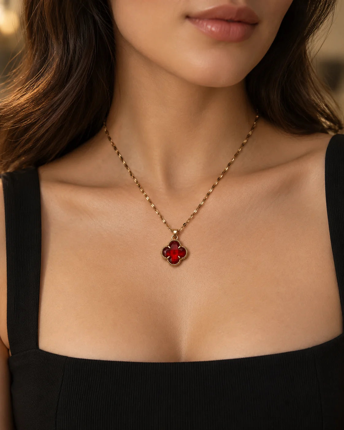 Fortuna cherry red clover necklace worn with a black square-neck top