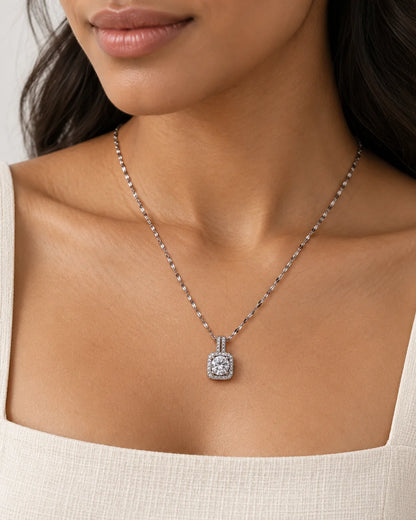 Model wearing the Celeste silver cushion halo pendant necklace with a square neckline