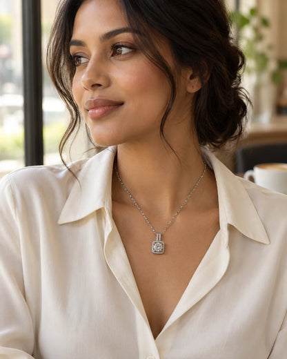 Model in an ivory blouse wearing the Celeste silver halo pendant in a café