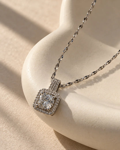 Celeste silver cushion halo pendant draped over a sculptural ivory curve