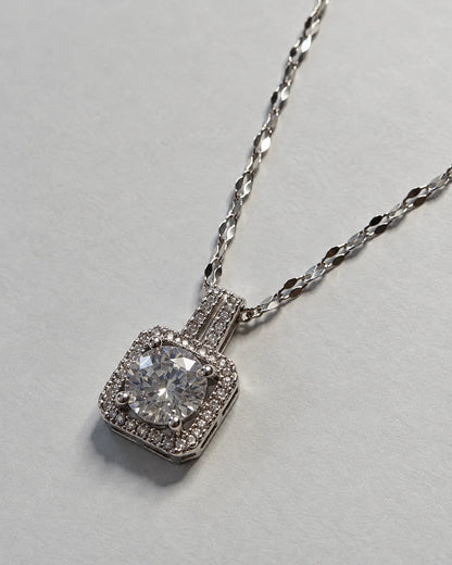 Celeste silver cushion halo pendant on a faceted link chain against soft grey