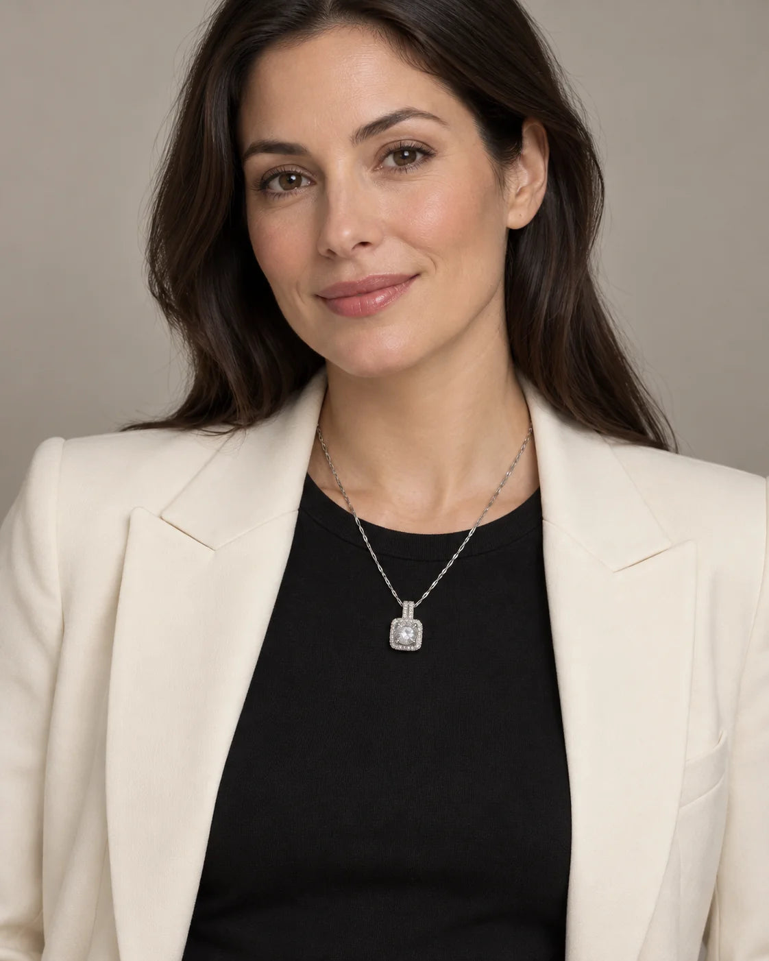 Model in a black top and ivory blazer wearing the Celeste silver halo pendant