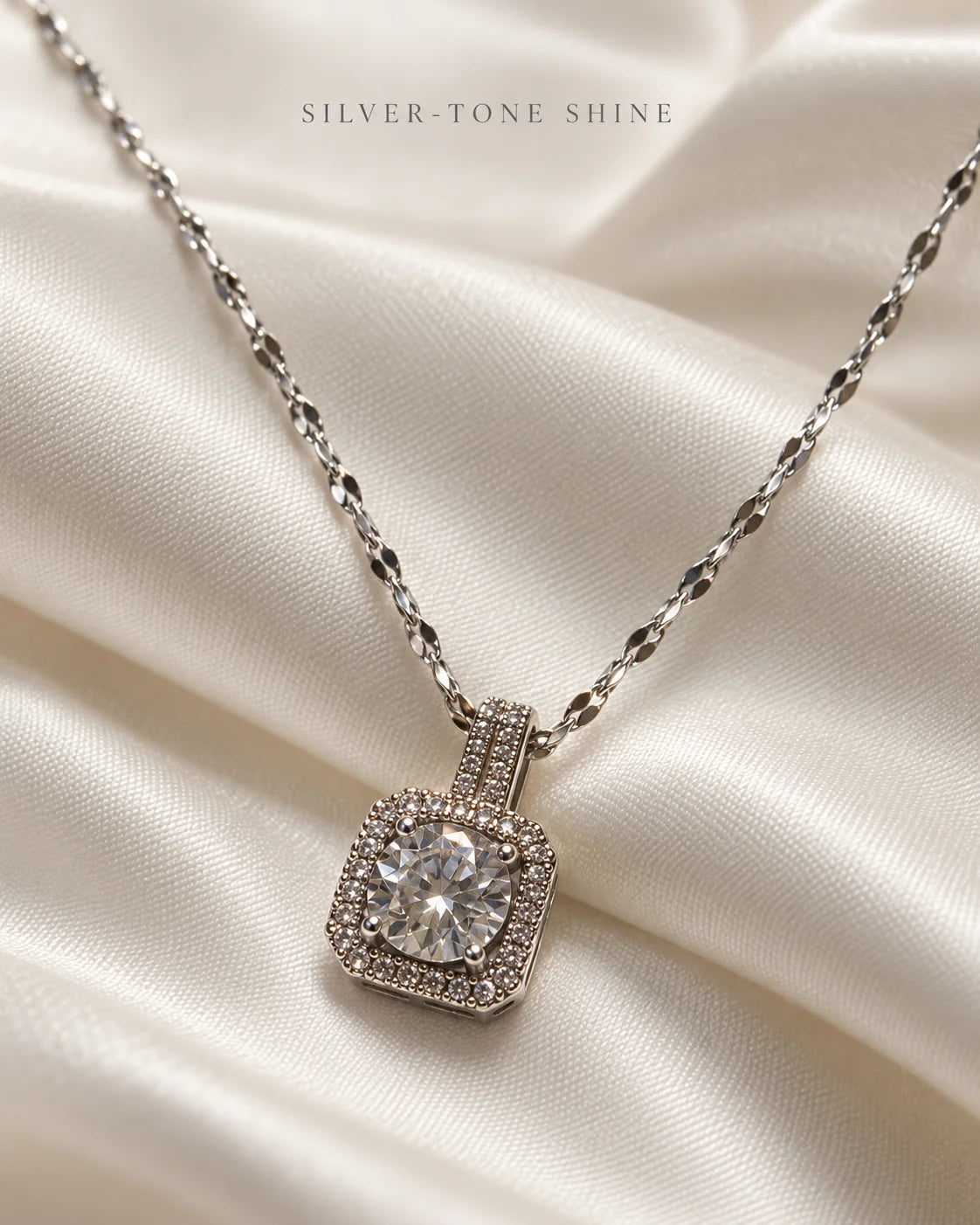 Silver-tone shine: Celeste cushion halo pendant on ivory satin