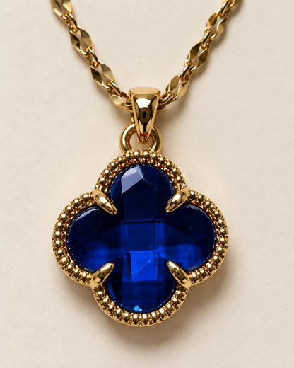 Close-up of the Fortuna sapphire blue clover pendant showing the faceted stone and claw setting