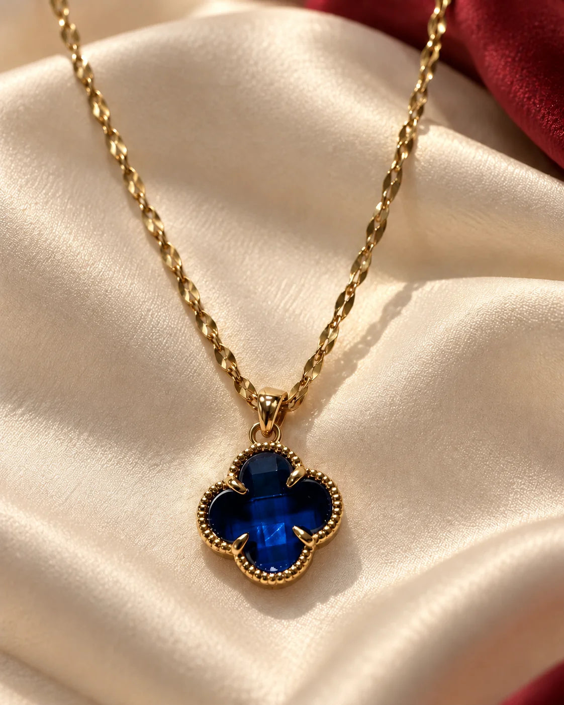 Fortuna sapphire blue clover necklace on cream satin