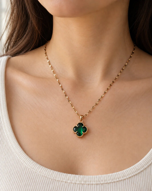 Model wearing the Fortuna emerald green clover necklace with an ivory scoop-neck top