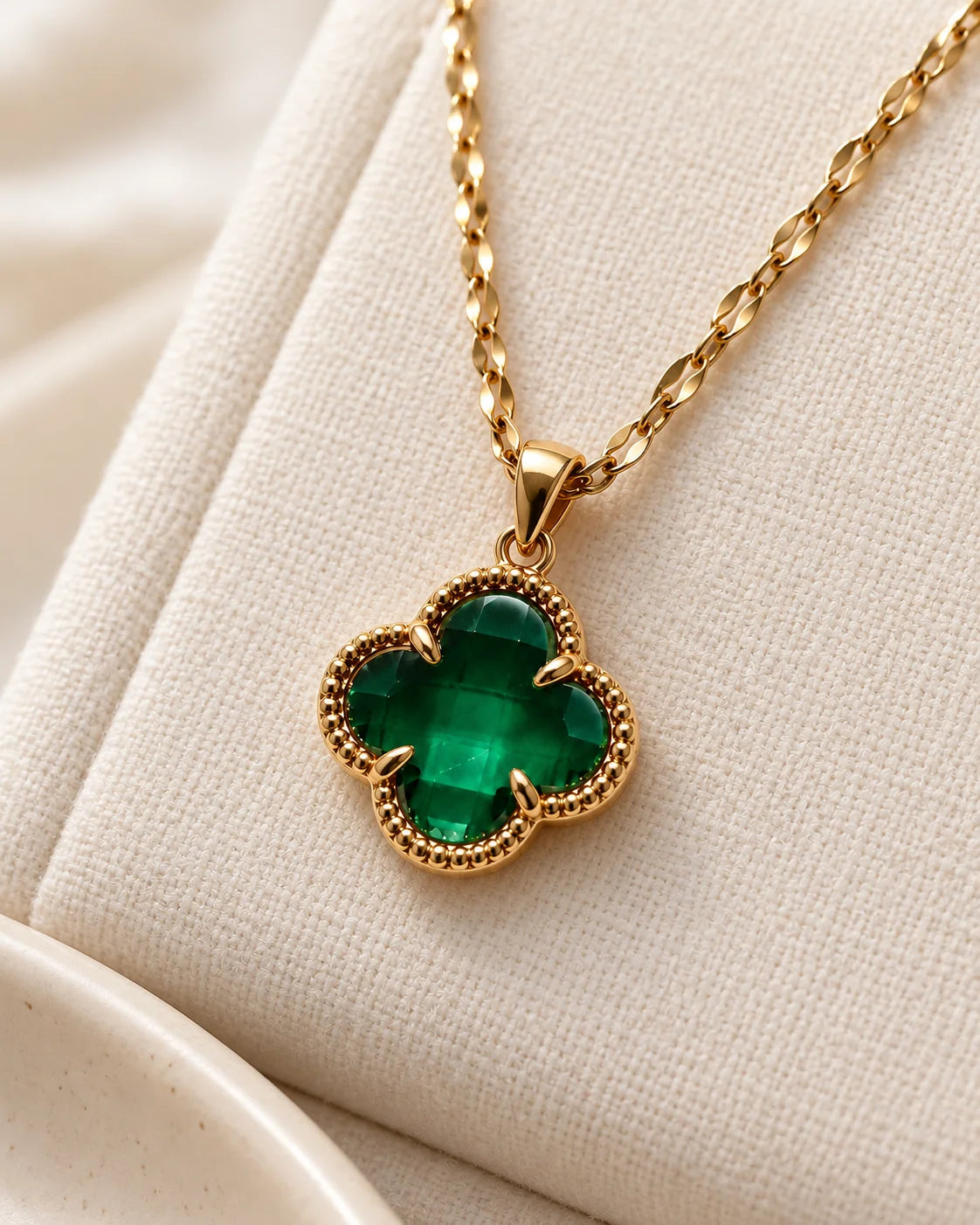Fortuna emerald green clover necklace on ivory linen