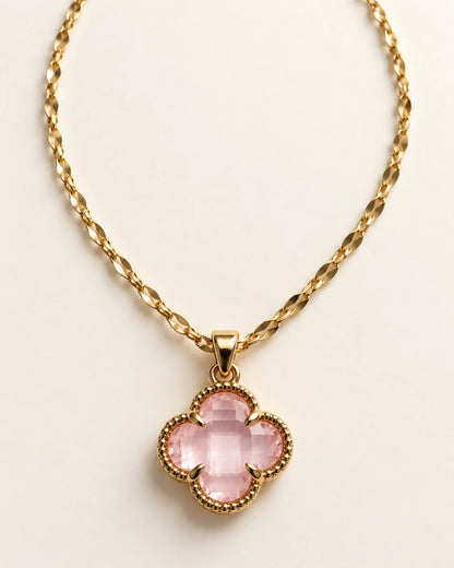 Fortuna baby pink clover pendant with a beaded gold-tone border on a cream background
