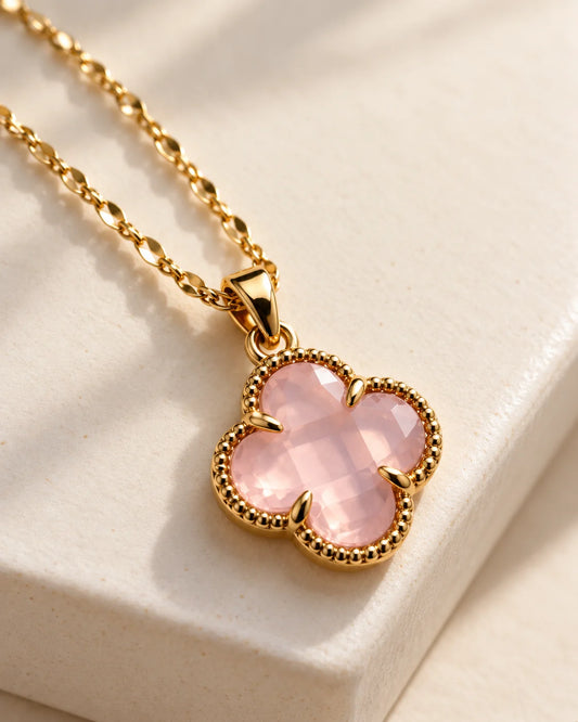 Fortuna baby pink clover pendant resting on the edge of an ivory ledge