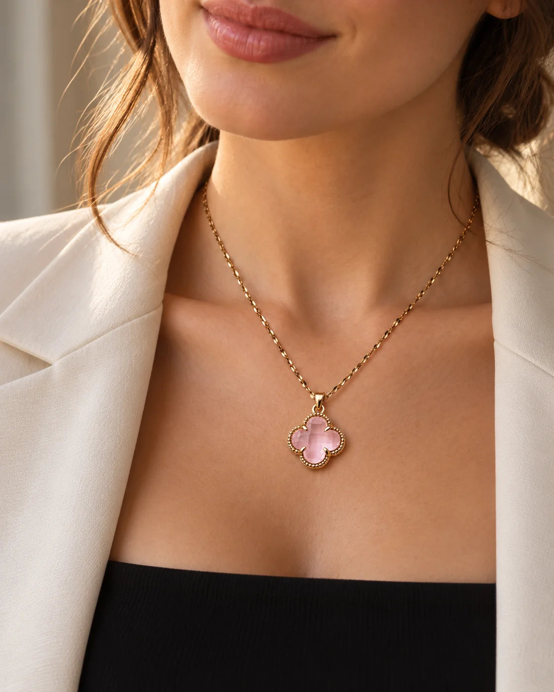 Model in a cream blazer wearing the dainty Fortuna baby pink clover necklace