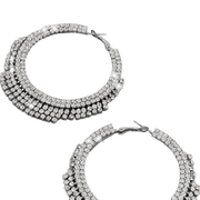 A pair of silver-tone hoop earrings covered in multiple rows of clear cubic zirconia stones, shown on a plain white background.