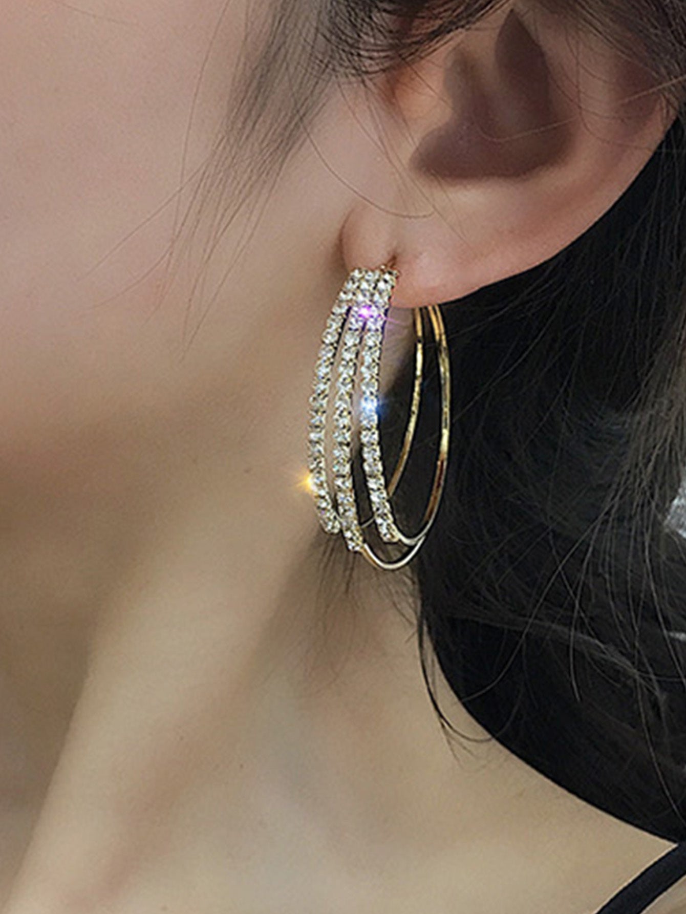 A close-up of a Woman model's ear wearing Celestia silver crystal drop earrings
