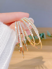 Close-up of silver-plated circle earrings with clear rhinestone crystals