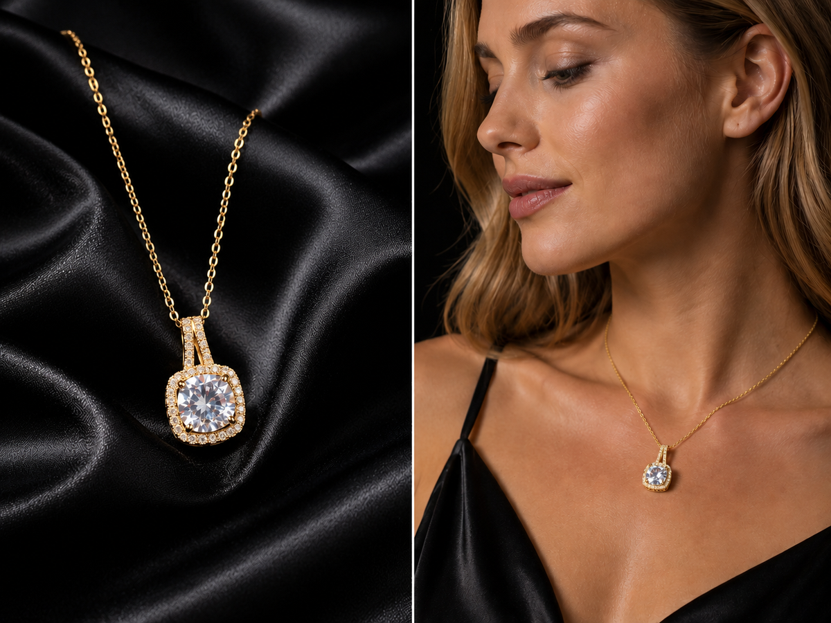 A gold pendant necklace with a cushion-cut clear gemstone and a halo setting, shown draped on black satin fabric alongside a model wearing it.