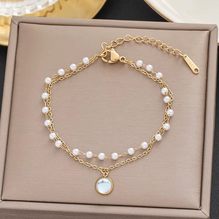 Gold bracelet with pearl accents on a beige jewelry box