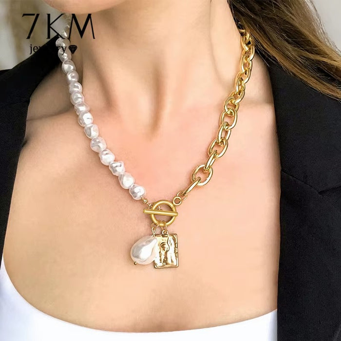 A close-up of a woman wearing a mixed-material necklace featuring a strand of white baroque pearls and a gold chain with a toggle clasp and a small pendant.