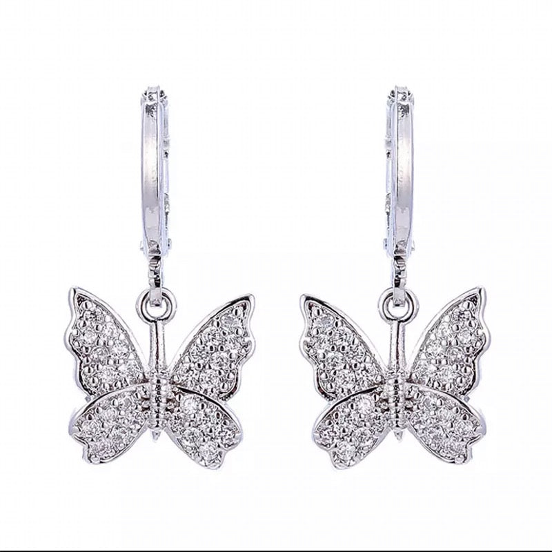 A pair of silver butterfly drop earrings with pavé-set clear stones, shown against a plain white background.